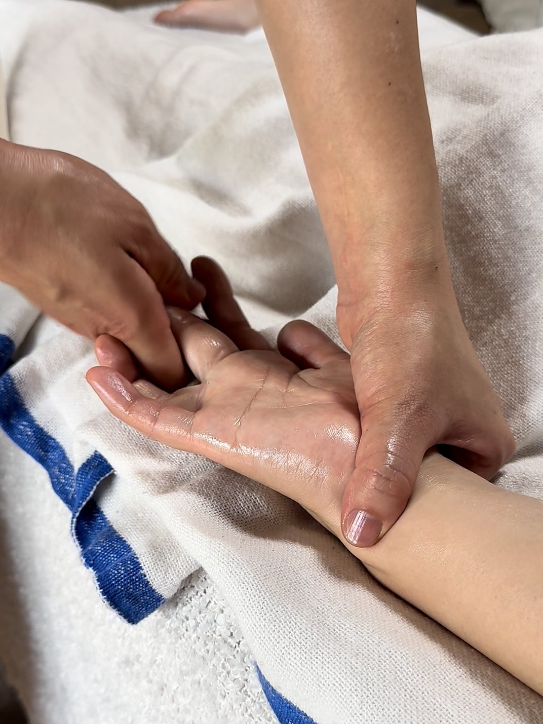 あたたかなオイルで、腕から手のひらへゆっくり流していく施術